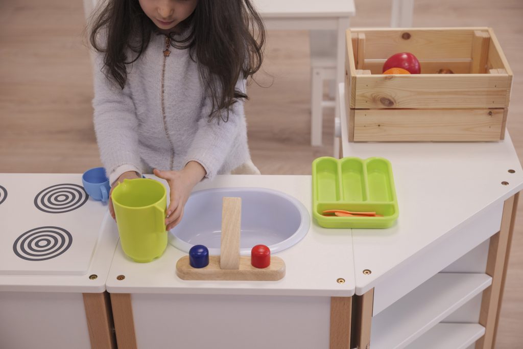 child plays wood kitchen montessori